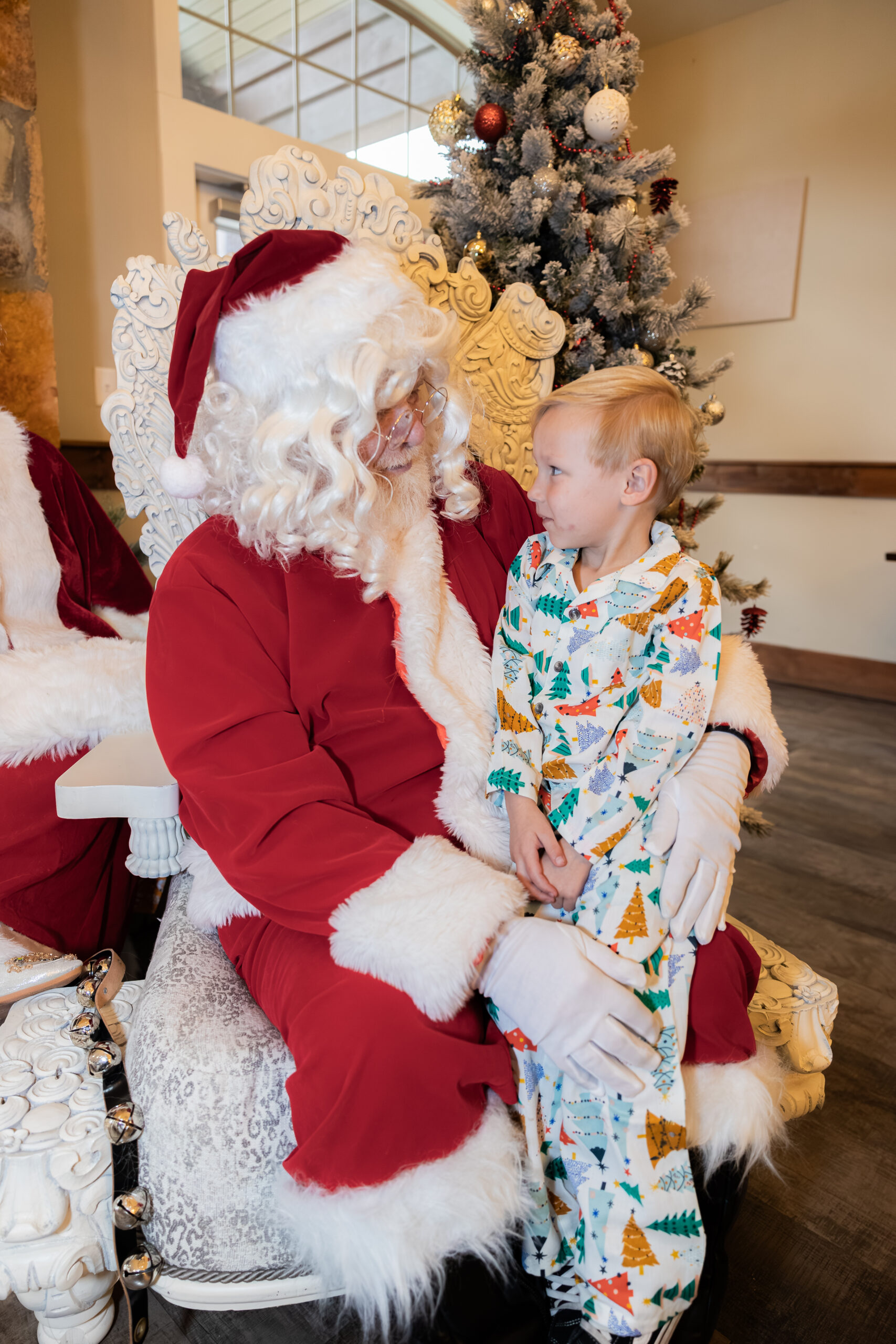 Child sitting on Santa's lap while Liza Hondros photographs them.