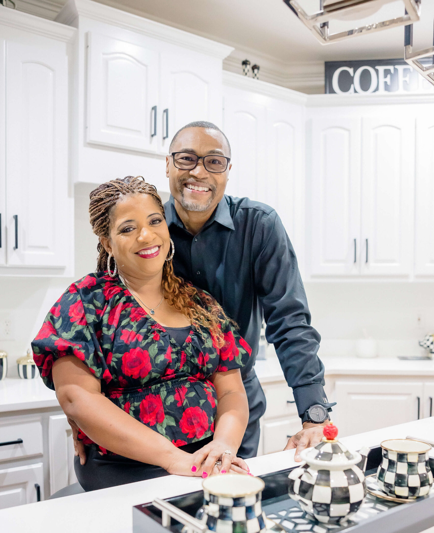 A happy couple smiles while standing in a modern kitchen after visiting movie theaters in Fayetteville NC